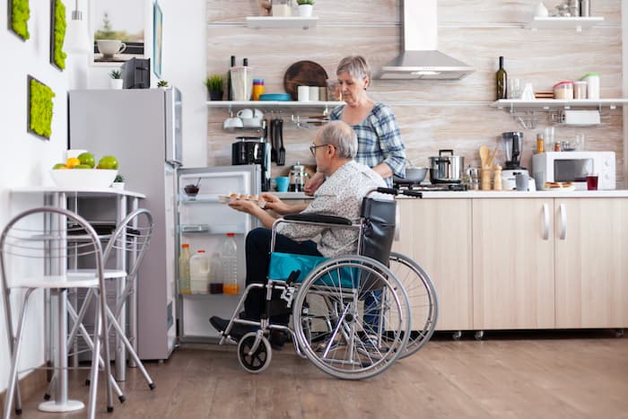 Disabled Man in a wheelchair taking eggs from the fridge